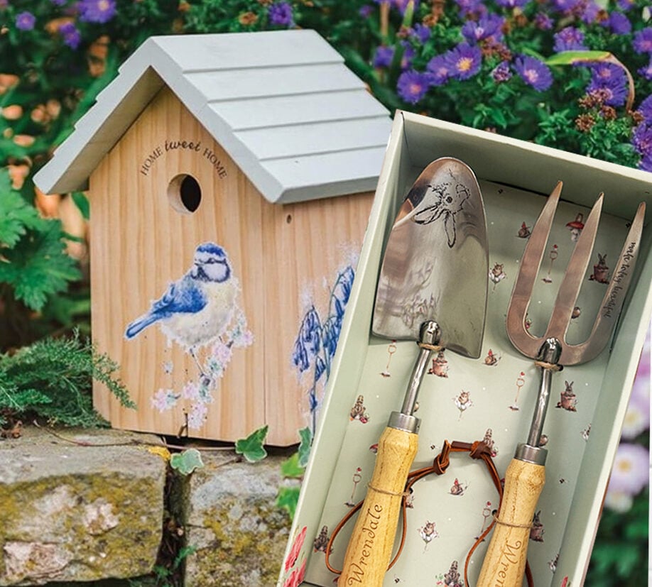 Wooden birdhouse with blue tit illustration beside a boxed gift set of garden tools with wooden handles and engraved designs.